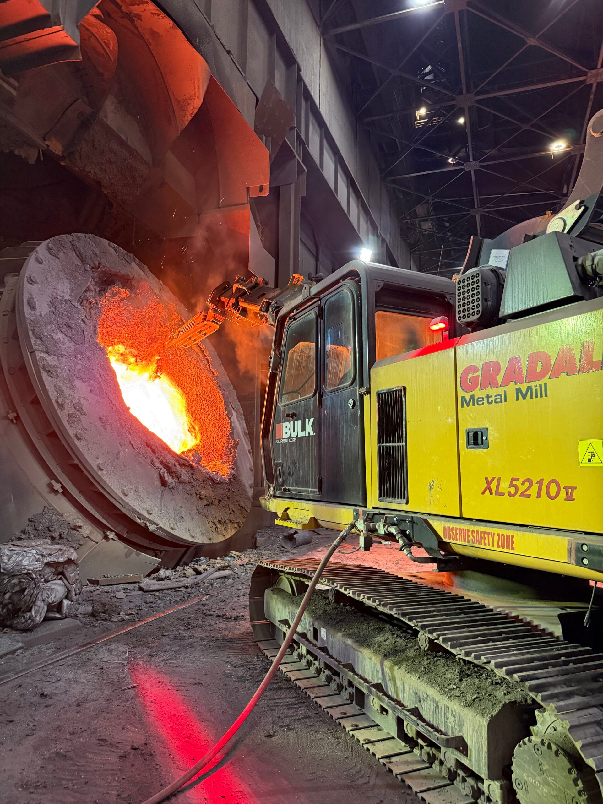 Bulk Equipment Gradall XL 5210 V reaching into a hot ladle in a steel mill